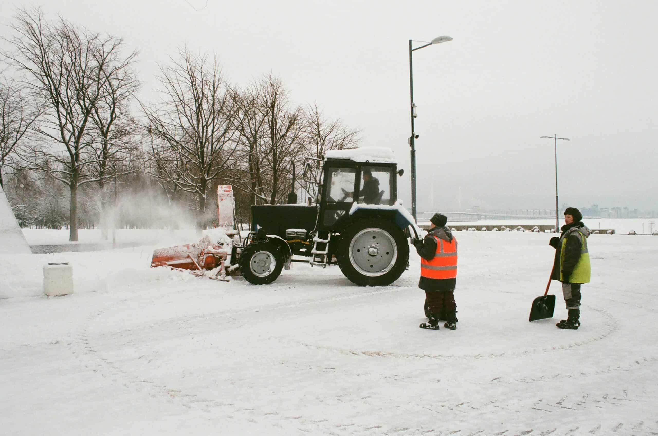 To display individuals deciding whether or not to use a snow plow or a snow shovel to clear a path.